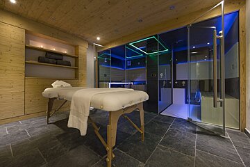 A massage table in a room with a glass shower