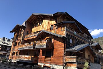 A large wooden building with a green sign on the side