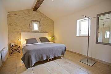 A bedroom with a bed and a mirror on the wall