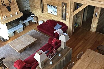 A living room with a red couch and a fireplace