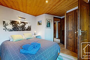 A bedroom with a bed and a door that says alpine-pro