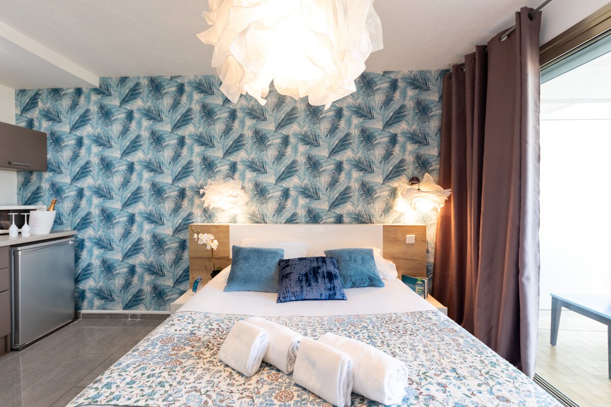 A bedroom with a bed and a chandelier hanging from the ceiling