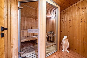 A wooden sauna with a glass door that says