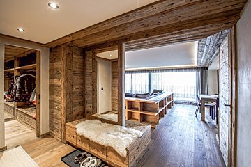 A hallway with wooden walls and a couch in the background