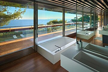 A bathroom with two sinks and a bathtub with a view of the ocean