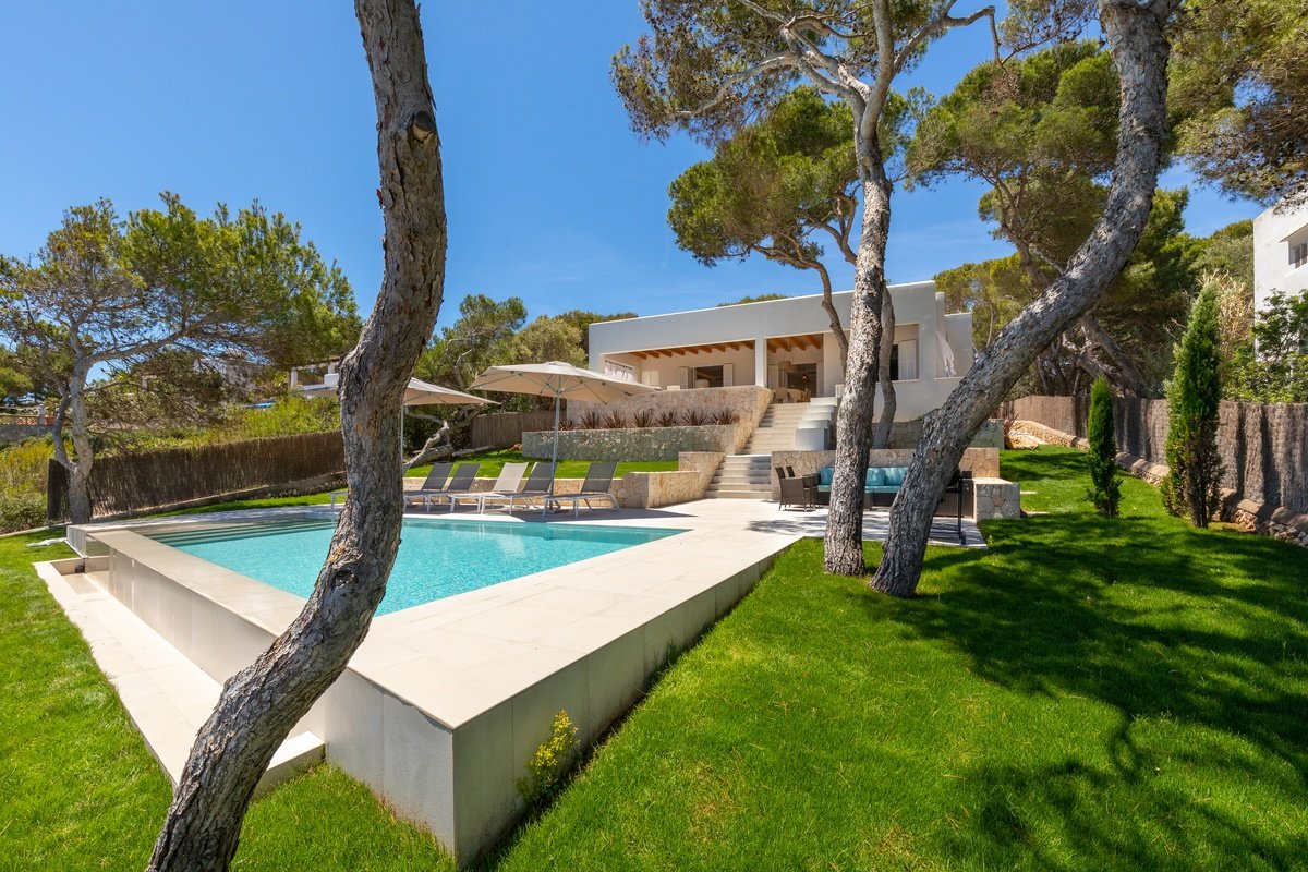 A large white house with a swimming pool in front of it