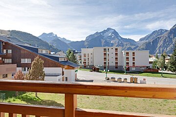 A balcony overlooking a city with mountains in the background