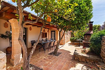 A patio with a table and chairs under a tree