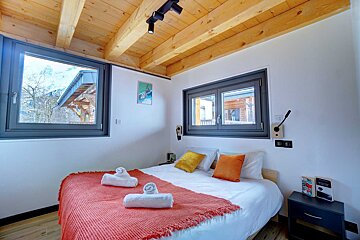 A bedroom with a bed and a book on a nightstand