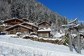 A ski lift is going up a hill in the mountains