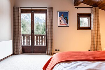 A bedroom with a poster on the wall that says chamonix