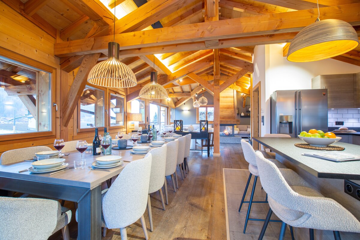 A dining room table with a bottle of wine on it