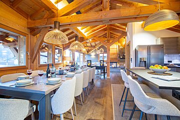 A dining room table with a bottle of wine on it