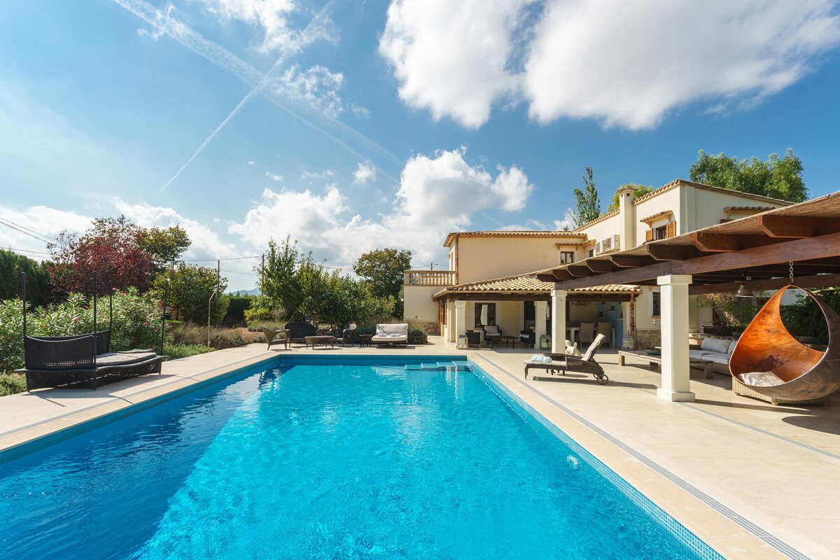 A large swimming pool with a house in the background