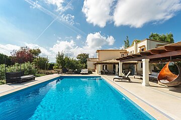 A large swimming pool with a house in the background