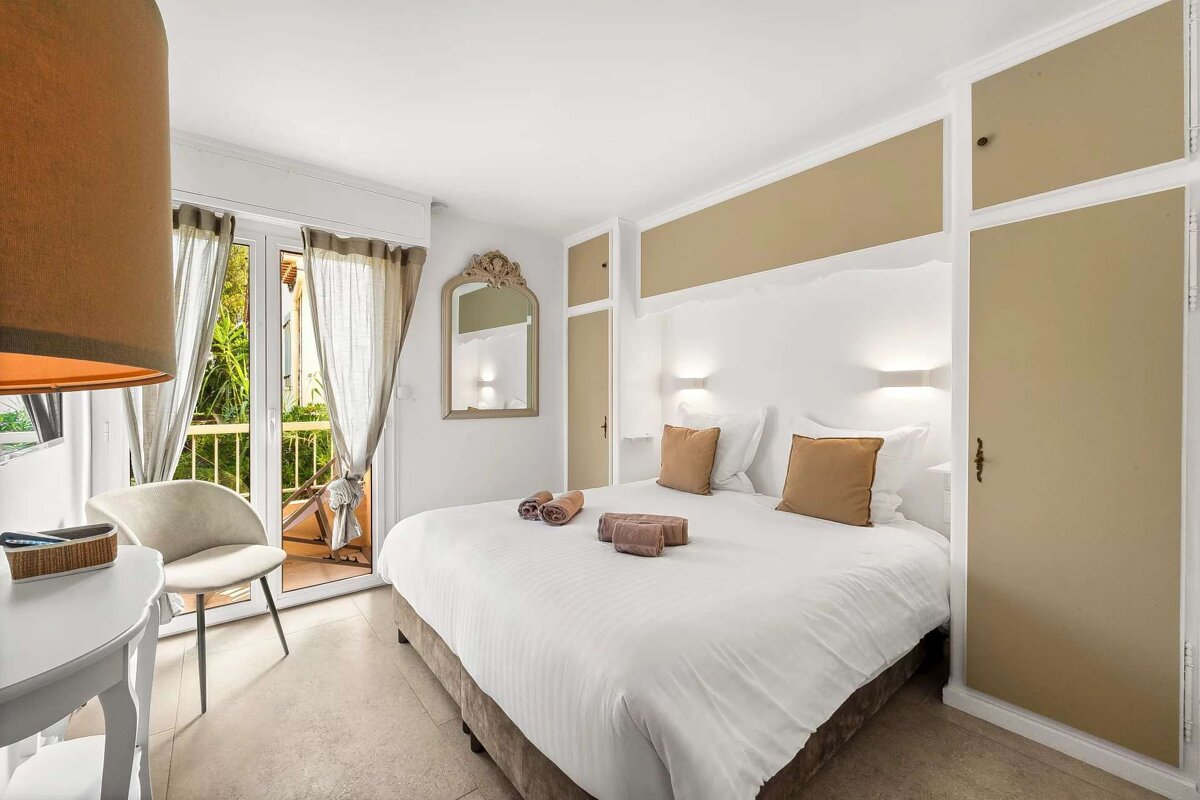 A bedroom with a large bed and a chair