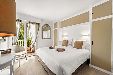 A bedroom with a large bed and a chair