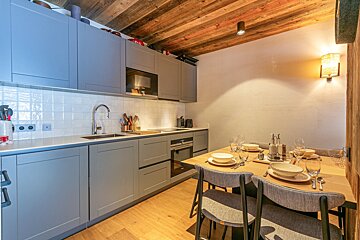 A kitchen with gray cabinets and a wooden ceiling