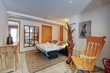 A bedroom with a rocking chair and a painting of a bear on the wall