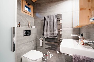 A bathroom with a toilet a sink and a towel rack