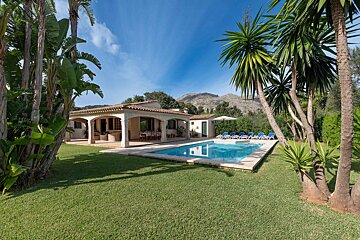 A house with a large swimming pool in front of it