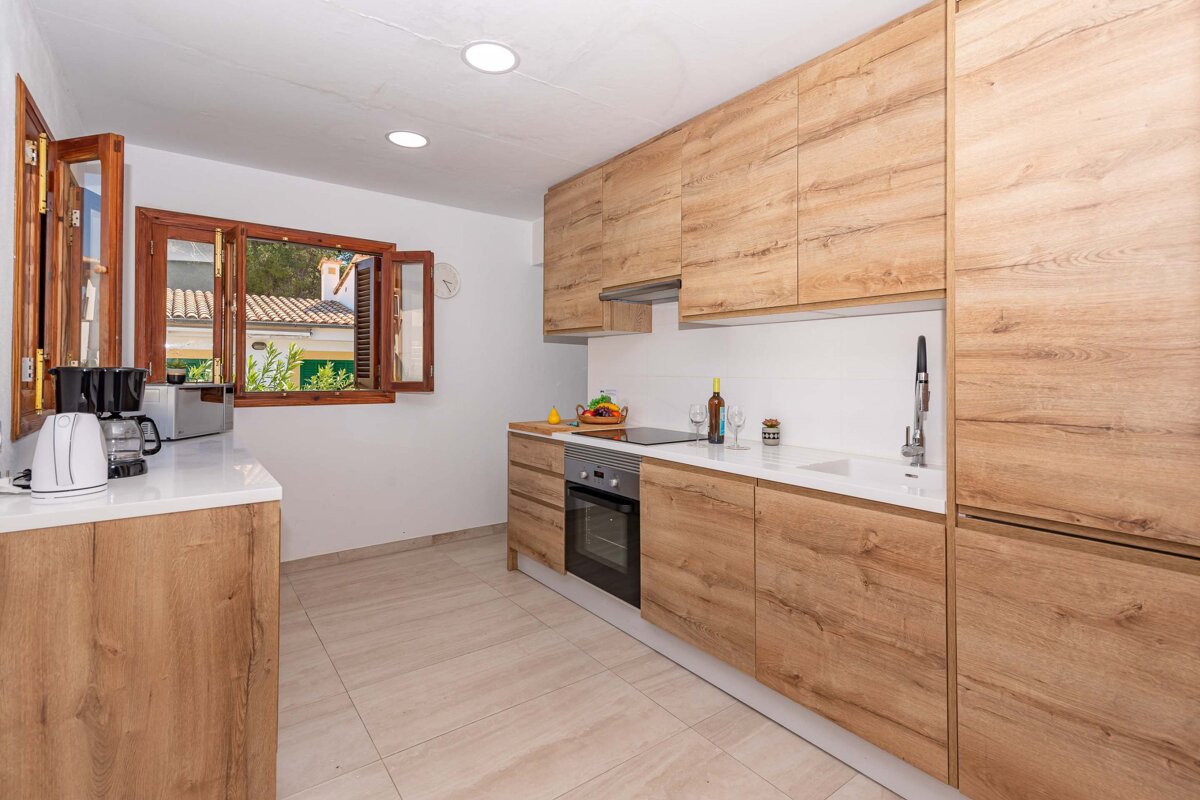 A kitchen with wooden cabinets and white counter tops