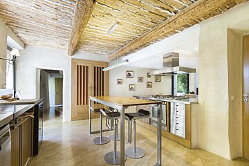 A kitchen with a wooden ceiling and stainless steel appliances