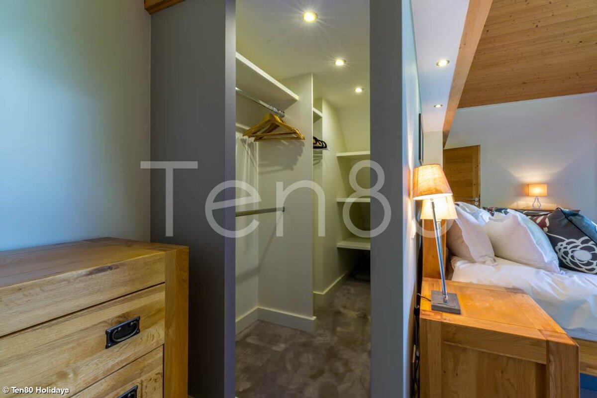 A bedroom with a walk in closet and the word ten8 on the wall