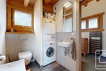 A bathroom with a washer and dryer stacked on top of each other