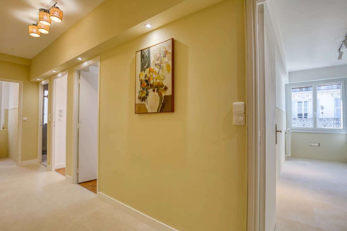 A hallway with a painting of flowers on the wall