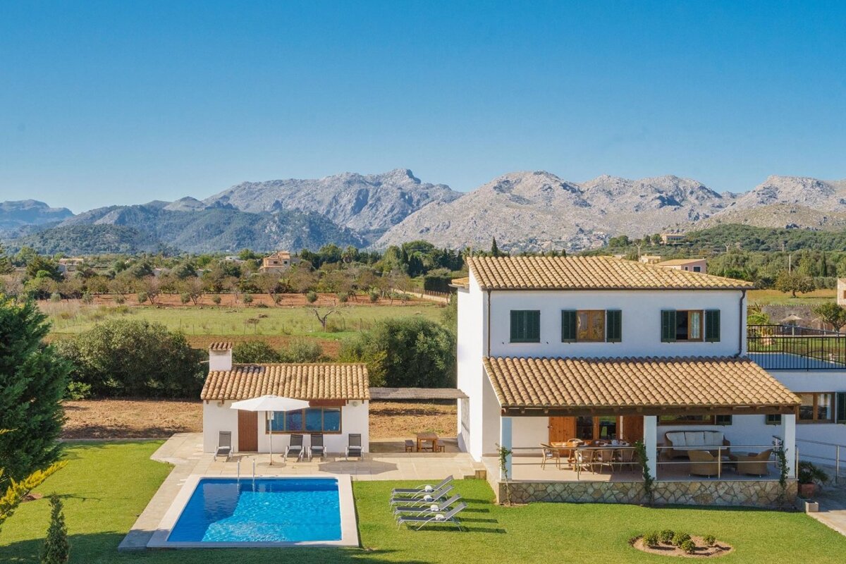 A house with a swimming pool and mountains in the background