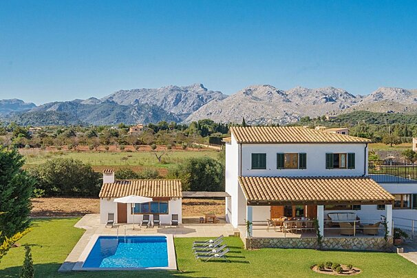 A house with a swimming pool and mountains in the background