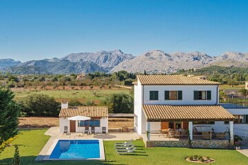 A house with a swimming pool and mountains in the background