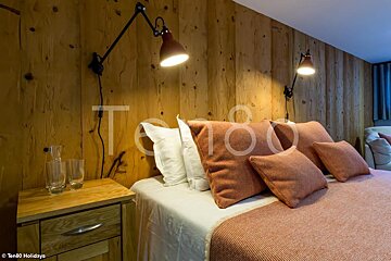 A bedroom with a wooden wall and the number ten80 on the wall