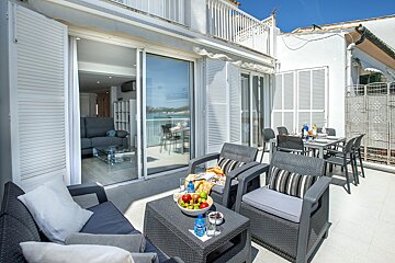 A patio with a table and chairs and a bowl of fruit on it