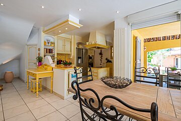 A kitchen with yellow cabinets and black chairs