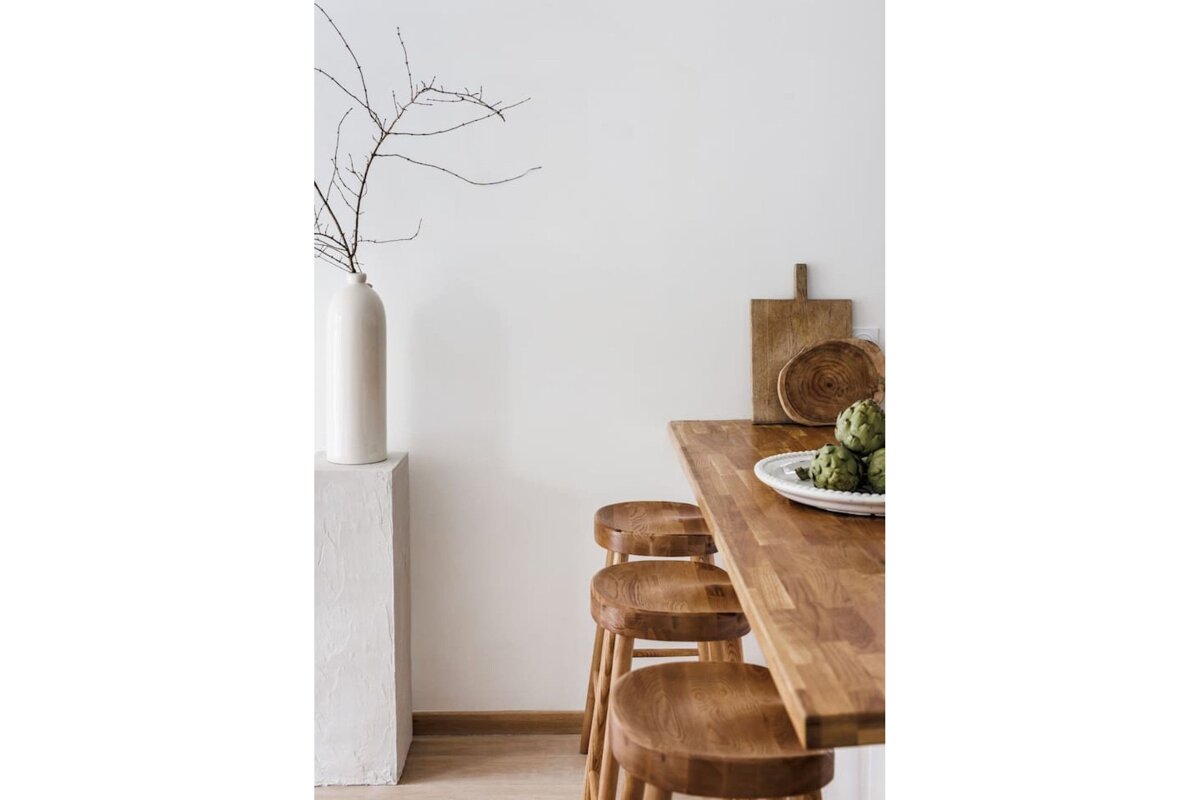 A wooden table with a bowl of artichokes on it