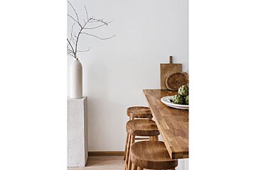 A wooden table with a bowl of artichokes on it