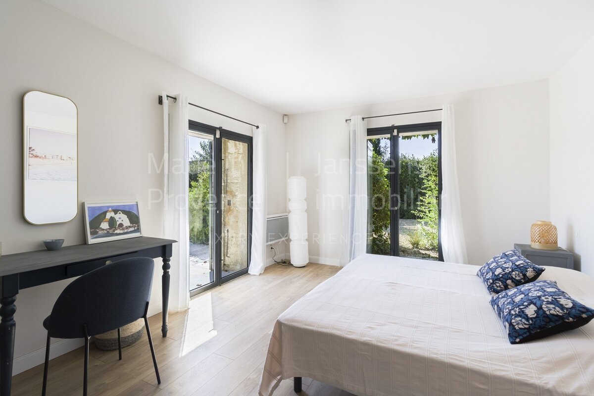 A bedroom with a large bed and a desk with the word immobilier on it