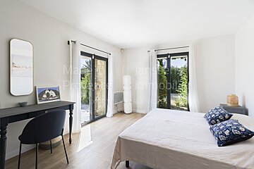 A bedroom with a large bed and a desk with the word immobilier on it