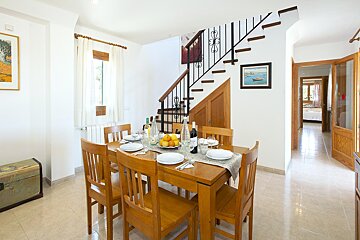 A dining room with a table and chairs and a staircase
