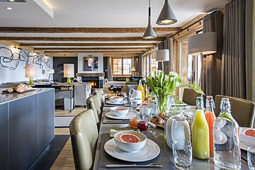 A dining room table with a bowl of grapefruit on it