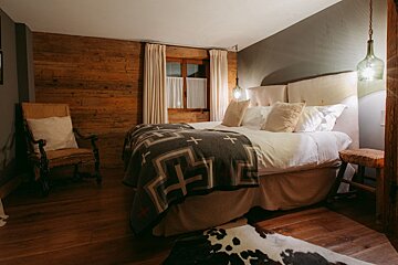 A bedroom with a large bed and a chair