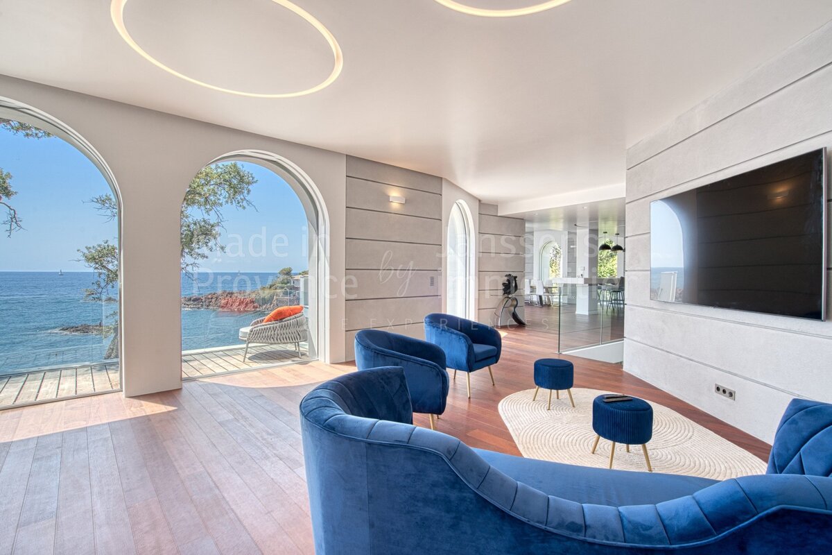 A living room with blue chairs and a flat screen tv