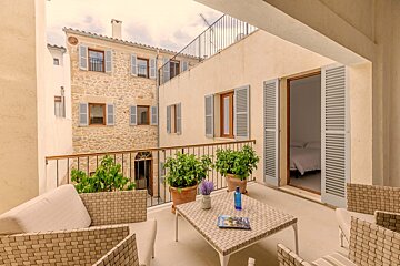 A balcony with a table and chairs and potted plants
