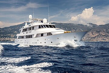A large white yacht is floating in the ocean