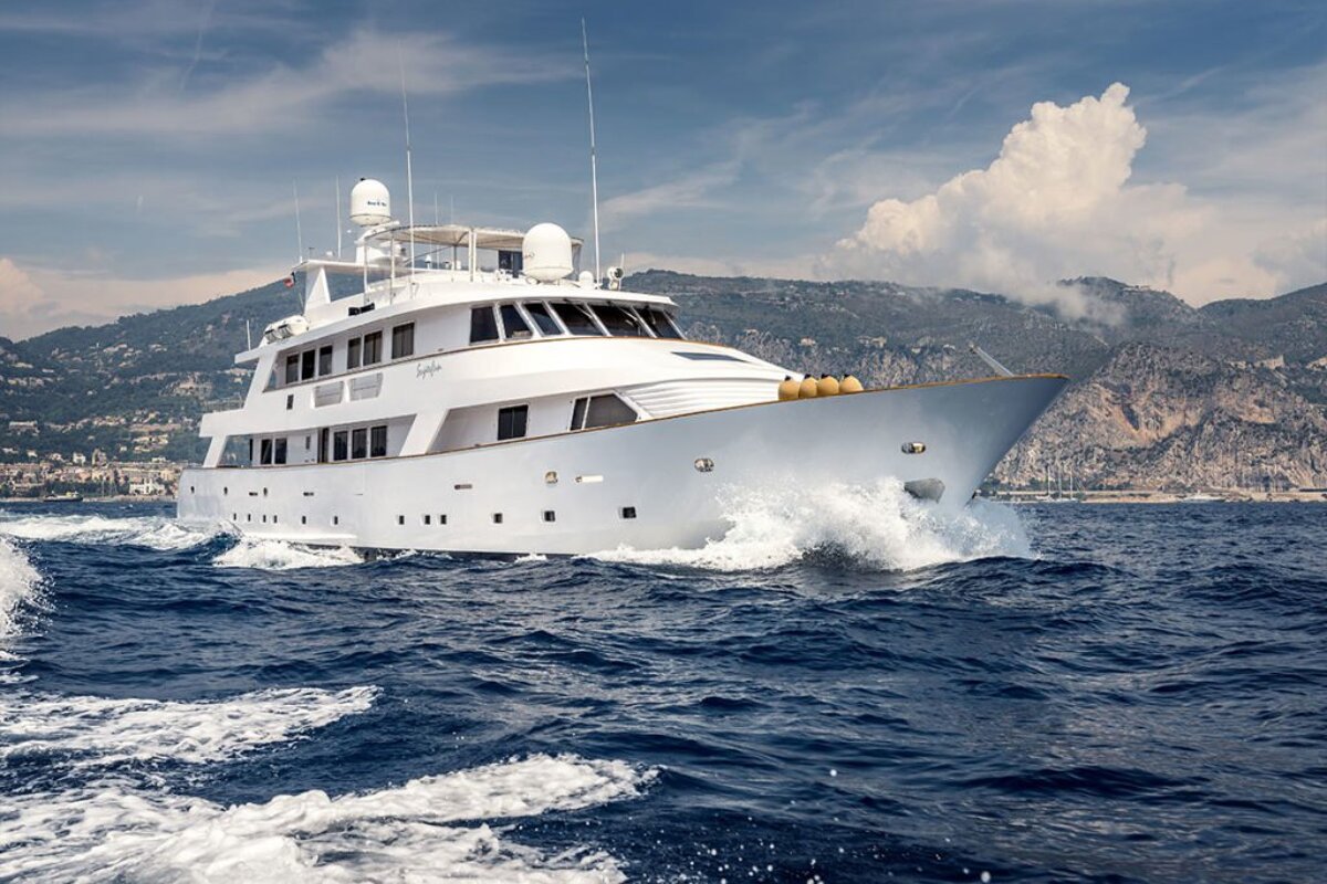A large white yacht is floating in the ocean
