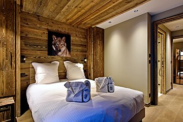 A bedroom with a picture of a wolf on the wall above the bed