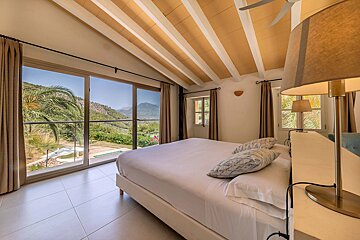 A bedroom with a large bed and a large window
