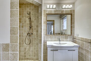 A bathroom with a walk in shower and a sink